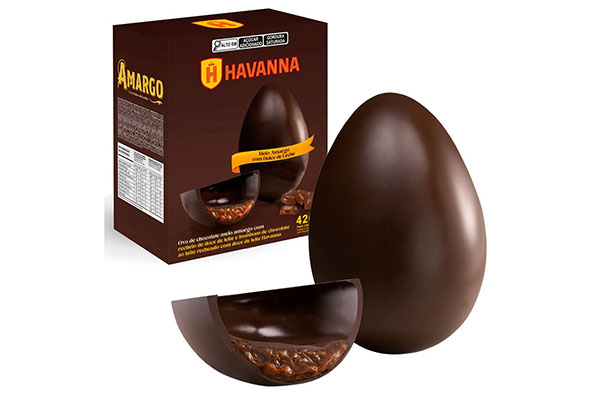ao fundo, caixa de papel com um ovo de chocolate dividido ao meio. À frente, o mesmo ovo fora da caixa