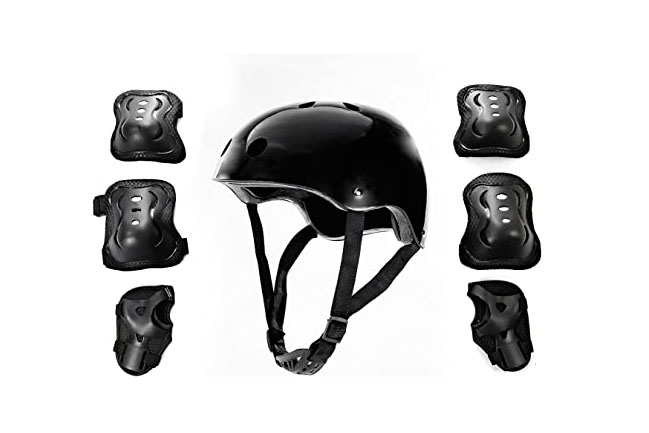 Kit de segurança preto. Um capacete grande no centro da imagem e, nas laterais: joelheiras, cotoveleiras e protetores de mão (três de cada lado).