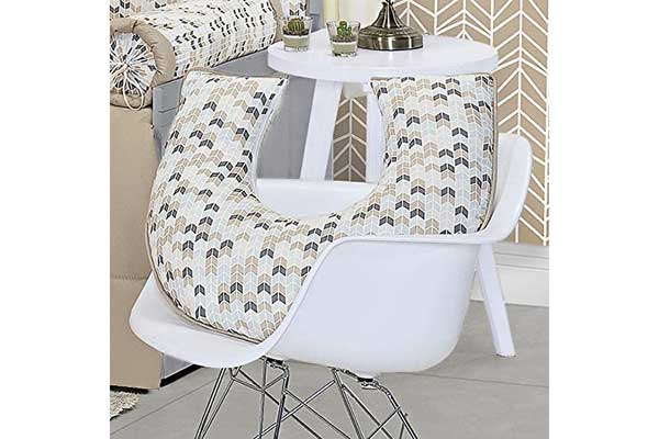 quarto de bebê com destaque para uma cadeira onde está posicionada uma almofada em formato de U