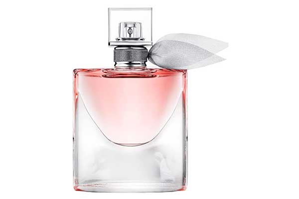 frasco de perfume retangular e transparente, com líquido rosado dentro. Na parte de cima, abaixo da tampa, há um laço
