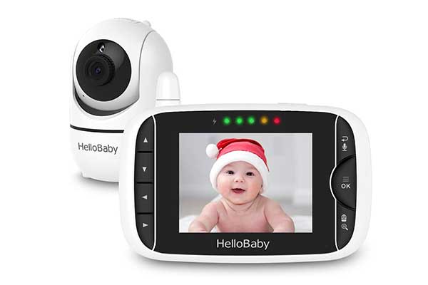 câmera arredondada pequena posicionada atrás de um pequeno monitor onde há a imagem de um bebê usando gorro de Papai Noel