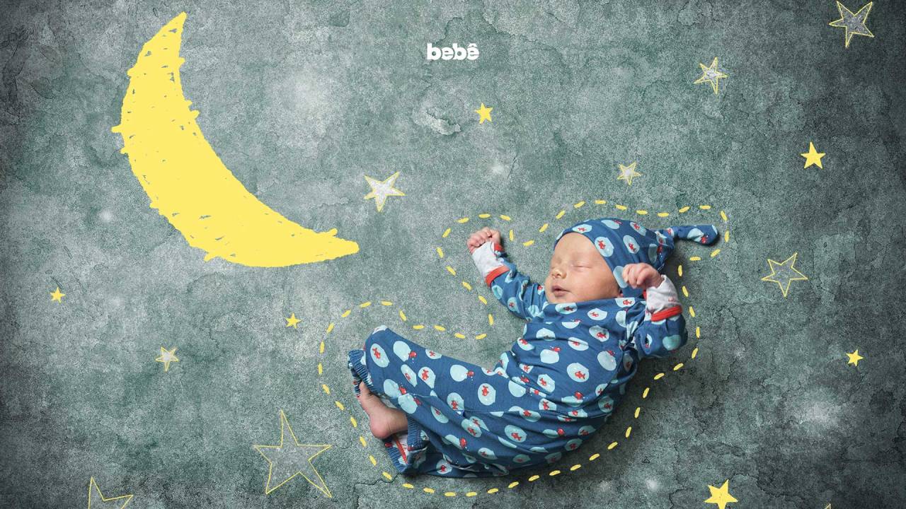 bebê de pijama e toupa deitado ao lado de ilustrações de nuvens e estrelas