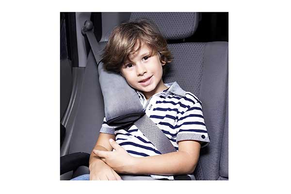 Menino sentado em um carro usando um cinto de segurança com um protetor almofadado