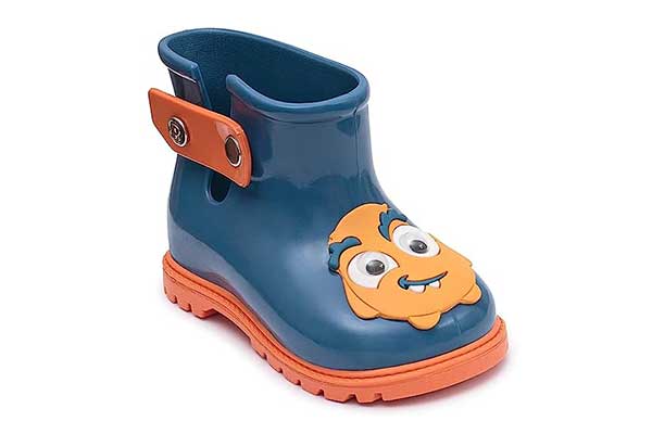 um pé de uma bota plástica azul com detalhe e solado laranja. Na parte de cima, há um outro detalhe em formato de monstrinho