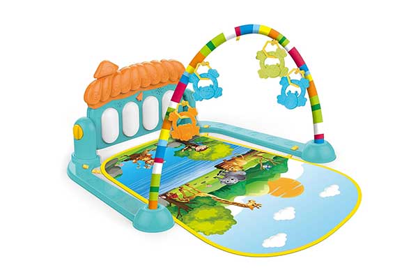 tapete colorido com estampa de safari e peças que imitam o teclado de um piano e um arco suspenso com brinquedos pendurados