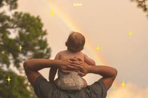 bebê no ombro do pai olhando para arco iris