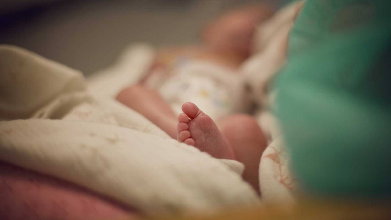 pé de um bebê deitado na cama de um hospital