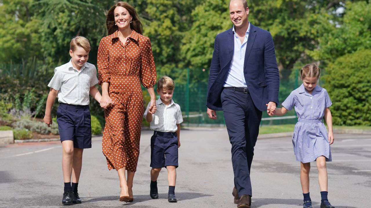 foto da família real andando de braços dados em um parque