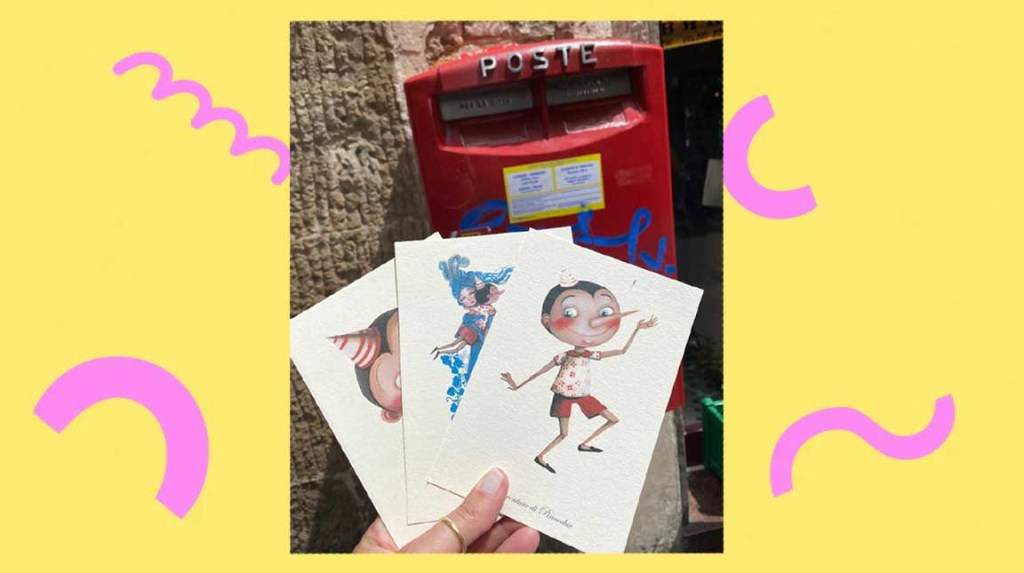 foto de uma mão feminina segurando três cartões postais. Ao fundo, a caixa de correio