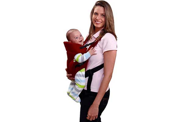 Canguru-Baby-Safe,-Multikids-Baby Mulher segurando uma bebê na parte da frente do corpo em um canguru. A criança está posicionada de frente para a mulher. Ambas olham para a câmera sorrindo