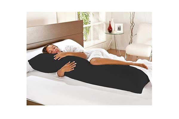 Travesseiro-de-corpo-com-fronha-100%-algodão-Preto---B.A mulher deitada em uma cama, abraçada a um travesseiro grande e preto, em formato de U