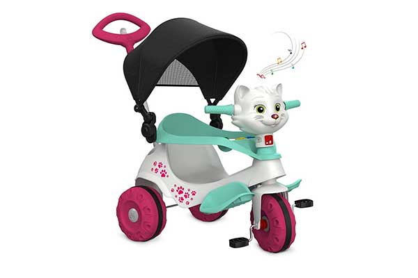 triciclo plástico infantil em branco, verde e rosa, com capota, proteção para a criança e haste na parte de trás, para condução do adulto. A parte da frente tem o formato de uma gatinha