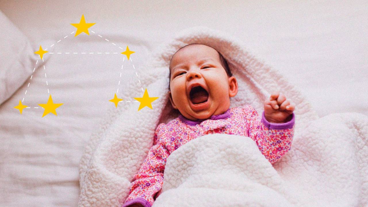 Bebê de macacão rosa, pele branca, deitado e coberto com manta branca. ELe está sorrindo com a boca bem aberta. Ao lado, há uma ilustração de constelação de Libra amarela.