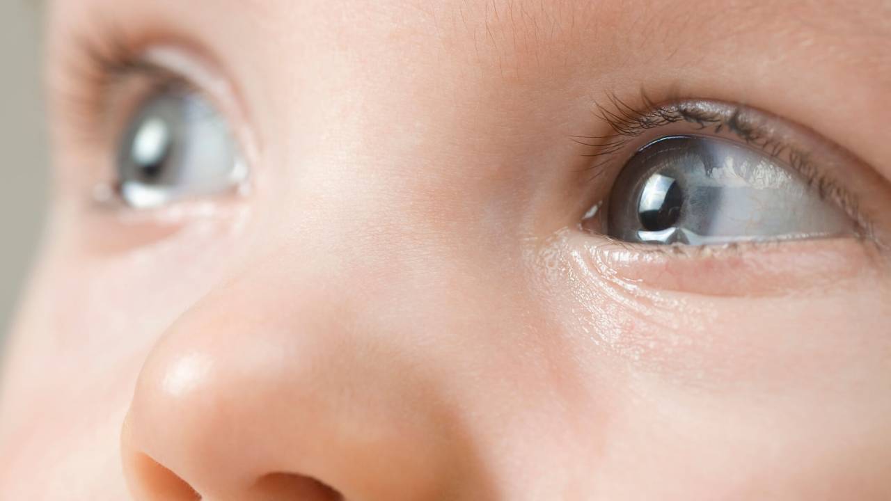 Foto fechado no rosto de um bebê branco com os olhos azuis.