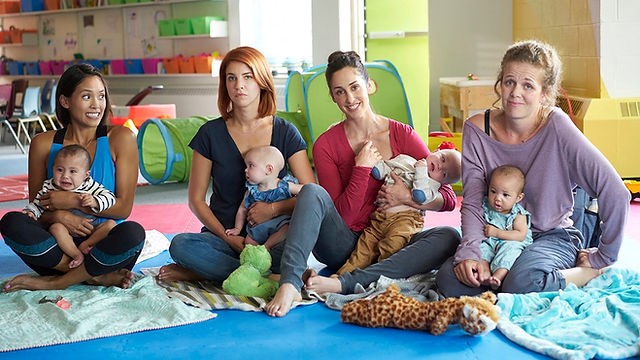Supermães Cena da série: quatro mães estão sentadas com seus bebês no colo.
