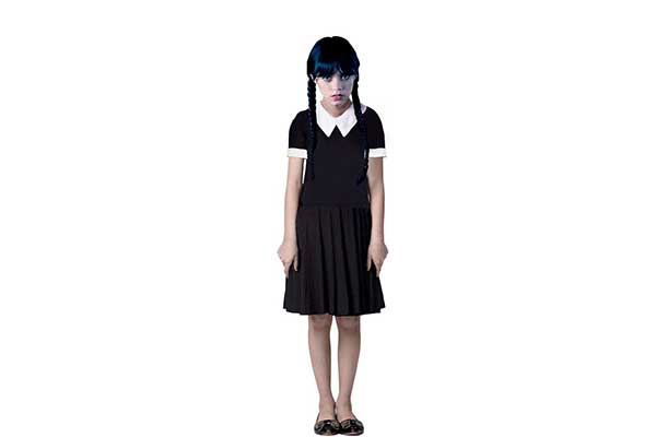 menina de cabelo comprido e duas tranças, usando saia preta e camiseta também preta com gola e barra da manga brancas
