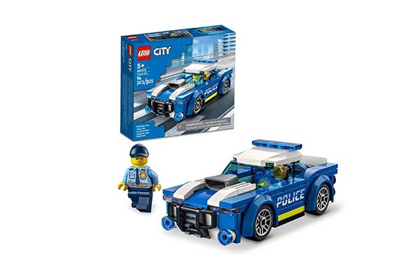 Acima, caixa de papel que a embalagem de um brinquedo de blocos de montar em formato de carro de polícia. Abaixo, está o mesmo carro e um boneco de policial.