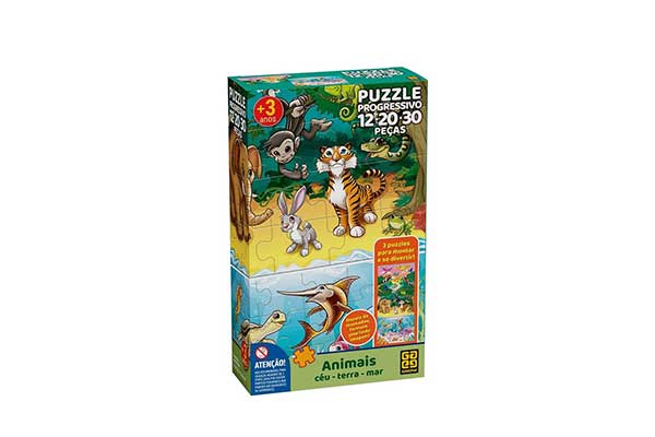 Embalagem de quebra cabeça em formato de caixa de papelão retangular, na vertical. Ela tem ilustrações de vários animais na floresta: em terra firme, estão, por exemplo, um macaco e um leão. No rio, há um peixe e uma tartaruga.