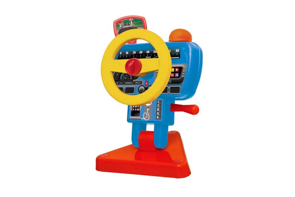 Sobre fundo branco, brinquedo que representa um volante de carro. Ele é amarelo, com buzina vermelha no centro, está fixado em um painel azul de botões pretos. A base inferior também é vermelha.