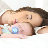 Mulher dorme junto com filho bebê
