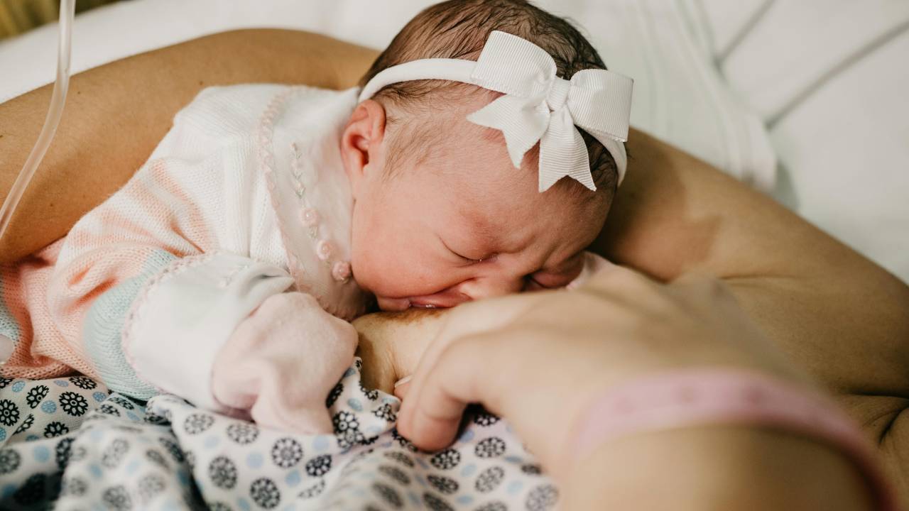 Bebê recem nascido mamando no peito / amamentação