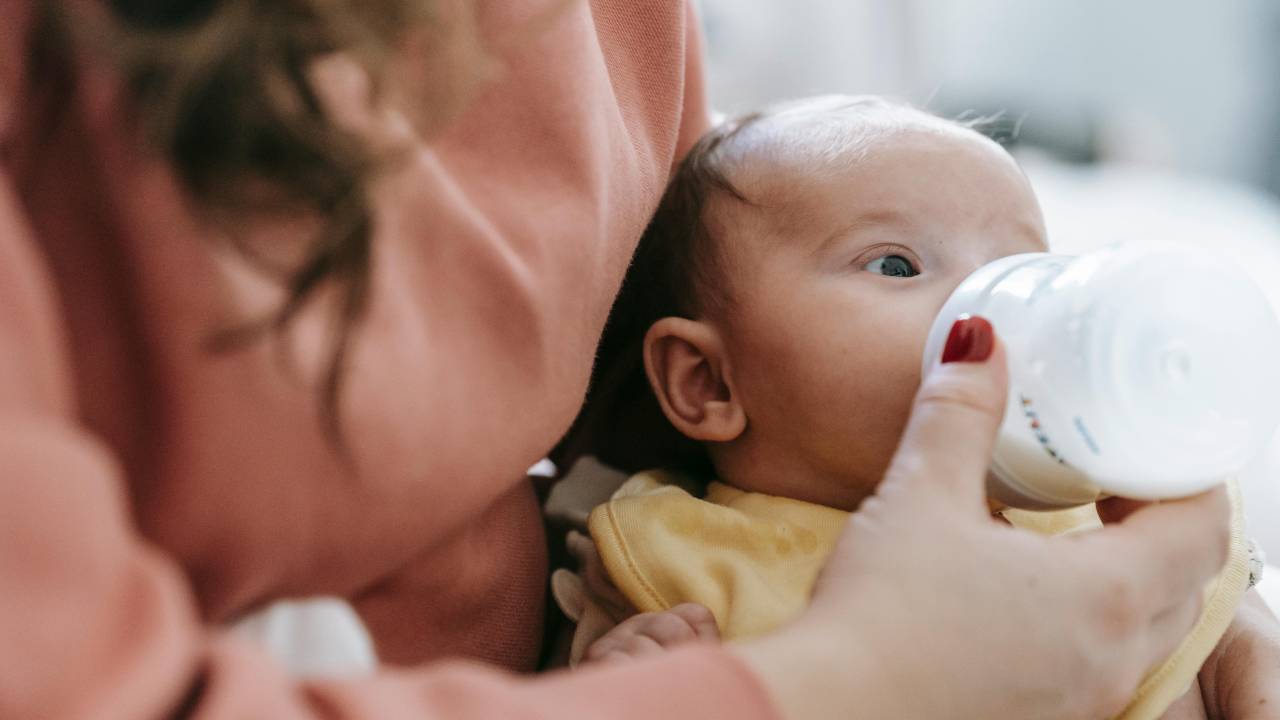 bebe tomando leite em copo de transição