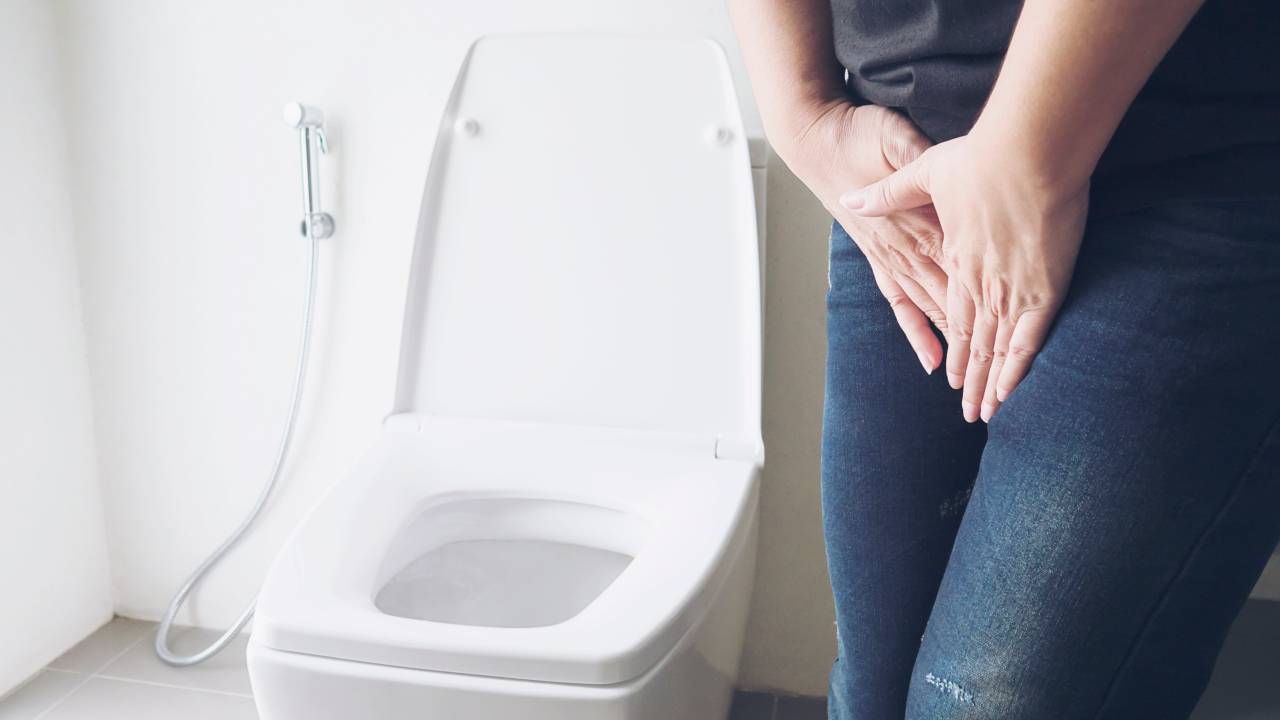 mulher apertada para ir ao banheiro fazer xixi